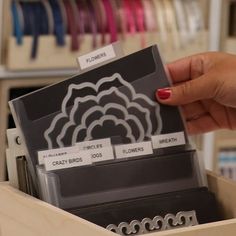 a person holding a card in a box with some sort of paper on top of it