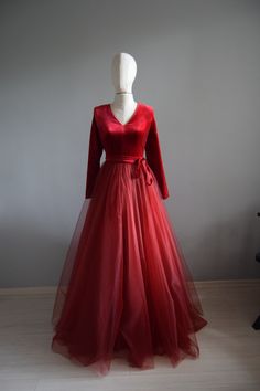 a mannequin wearing a long red dress with a bow at the waist and neckline