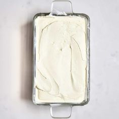 a pan filled with white frosting sitting on top of a counter