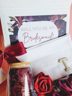 the bridesmaid gift box is filled with red flowers and personalized items for her