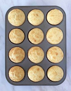 muffins in a baking pan on a marble counter top, ready to be baked