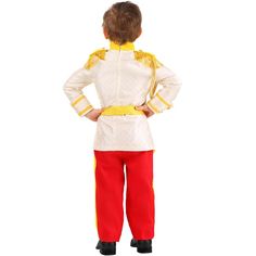 a little boy dressed in a white and yellow uniform standing with his hands on his hips