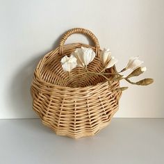 a wicker basket with white flowers in it