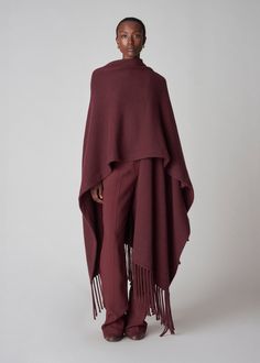 Woven poncho with trimmed with black fringe. Fused lining. One size. Details 90% Wool 10% Cashmere Bordeaux 9163WCM-F24 One size Model is 5'10" Fall Poncho, Fringe Poncho, Black Poncho, Poncho Shawl, Wool Poncho, Fringed Poncho, Poncho Tops, Exclusive Dress, Black Fringe