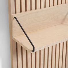 a wooden shelf with a black handle on it