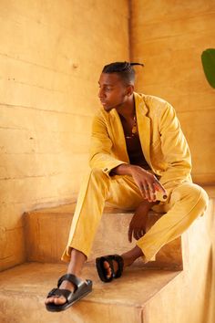 a man sitting on some steps wearing sandals