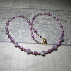 "Amethysts feature in this purple necklace. Running the length of this necklace are 4x2mm opaque/clear purple Czech Crystal beads. At each end of the necklace the Crystals alternate first with a 4mm Amethyst and then with a 6mm purple Glass pearl bead, after four Amethyst beads they are replaced with 6mm Amethysts. While in the centre of the necklace the Amethyst beads are 8mm. The necklace is approx 57.5mm (22.75\") long. All the metal work is Gold plated Stainless Steel including the magnetic clasp and the earwires on the free matching earrings. Necklace and earring come enclosed within a purple Silk bag. Amethyst helps to relax mind, body and spirit Amethyst is connected to the third eye, the centre of spirituality and intuition. Amethyst brings tranquillity, calm and peace of mind. It Adjustable Lavender Single Strand Necklace, Purple Single Strand Beaded Necklace Gift, Gift Purple Single Strand Beaded Necklace, Purple Single Strand Beaded Necklace For Gift, Lavender Single Strand Necklace Gift, Lavender Single Strand Necklace For Gift, Purple Necklace With Spacer Beads As Gift, Purple Necklace With Spacer Beads For Gift, Purple Necklaces With Spacer Beads For Gift