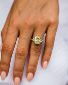 a woman's hand with a yellow diamond ring on her left hand and the words bridallence written in white