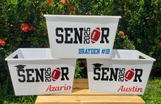 three white plastic containers with red and blue letters on them sitting on a wooden table