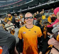 a man with blindfolds standing in the middle of a crowd at a sporting event