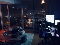 a living room filled with furniture and a computer desk in front of a large window