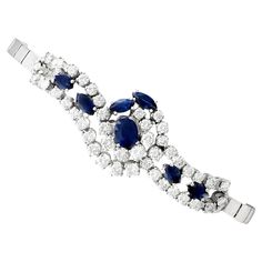 A stunning vintage 3.32 carat sapphire and 4.35 carat diamond, 14k white gold bracelet; part of our diverse diamond jewelry and estate jewelry collections. This stunning, fine and impressive vintage sapphire and diamond bracelet has been crafted in 14k white gold. The feature fully articulated central setting has a scrolling design, displaying a central four claw set oval mixed cut sapphire. A further six individually four claw set marquise diamonds ornament the setting. The scrolling design is Wedding Sapphire Diamond Bracelet With 17 Jewels, Wedding Sapphire Bracelet With Brilliant Cut Diamond, Brilliant Cut Sapphire Bracelet For Wedding, Brilliant Cut Sapphire Bracelets For Wedding, Wedding Sapphire Bracelet With Brilliant Cut, Sapphire Diamond Jubilee Bracelet For Wedding, Classic Sapphire Diamond Bracelet With Brilliant Cut, Sapphire Diamond Bracelet For Wedding, Elegant Sapphire Diamond Bracelet For Wedding