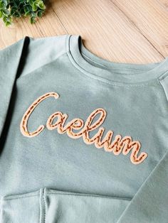 Felt Embroidery Sweatshirt, Green Long Sleeve Tops With Name Print, Hand Embroidery Name Sweater Diy, Cotton Long Sleeve Sweatshirt With Name Print, Hand Stitch Name On Sweater, Embroidery Hoodie Ideas, Hand Embroidered Name Sweatshirt, Hand Embroidery Sweatshirt, Baby Sweater Embroidery Name Diy