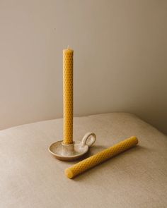 a yellow candle sitting on top of a white table