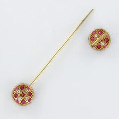 a pair of red and white diamond earrings with a gold stick in the shape of a circle