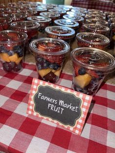 jars filled with fruit sitting on top of a red and white checkered table cloth