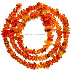 orange glass beads are arranged on a white surface