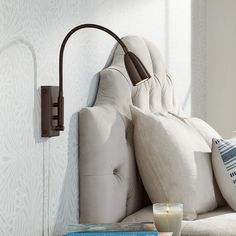 a white couch sitting next to a wall mounted lamp