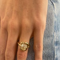 a close up of a person's hand with a gold ring on their finger