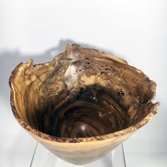 a wooden bowl sitting on top of a glass stand