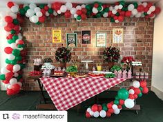 a table set up for a party with red, white and green balloons