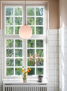 a vase with flowers sitting on a window sill next to a radiator