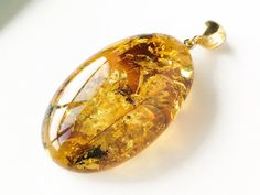 What an exquisite amber piece - intense shiny cognac color medium size amber pendant with golden rays inside. Shaped into beautiful oval shape it looks royal and high-value. Its high quality shines as bright as little rays of sun. MATERIALS AND SIZE: Stone: 100% Natural Baltic Amber Other materials: Luxury Amber Oval Necklace, Elegant Amber Oval Cabochon Necklace, Elegant Amber Oval Pendant Necklace, Luxury Amber Necklace With Polished Finish, Elegant Oval Amber Necklaces, Elegant Yellow Cabochon Necklace, Amber Cabochon Round Pendant Necklace, Amber Cabochon Oval Pendant Necklace, Amber Necklace With Large Oval Pendant