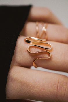 The elegant curves of this design are wave-like, creating a sense of movement and fluidity that is versatile and organic. The ring is handcrafted out of a D-shaped (half round) wire that is then flattened and formed into this three dimensional form. This listing is for ONE single ring in 14K Rose Gold Fill The thickness of the metal used with this ring measures approximately 2mm which gives this piece a durable and sturdy design while maintaining that effortless look. While this ring is gorgeous Modern Twist Rose Gold Ring, Elegant 14k Gold Wire Wrapped Rings, Minimalist Rose Gold Spiral Jewelry, Elegant Spiral Bypass Ring, Gold Curved Jewelry With A Modern Twist, Gold Jewelry With A Modern Curved Design, Modern Twist 14k Rose Gold Jewelry, Elegant Spiral Rose Gold Ring, Minimalist Wire Wrapped Rose Gold Ring