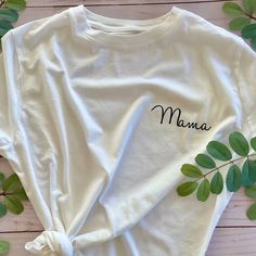 Share your greatest achievement with an everyday white tee dedicated to being a mama. This white T is the perfect shirt for running errands, hanging with your little ones, or celebrating being a mom with your mom squad. T-shirts are unisex sizing. Recommended washing instructions: Wash and dry garments inside out Wash with cold or warm water Use a mild detergent Tumble dry low or hang dry Do not iron directly on the design White Relaxed Fit T-shirt For Family Matching, White Letter Print T-shirt As Gift, White Cotton T-shirt As Gift, Mother's Day Graphic Tee T-shirt, White T-shirt For Mother's Day Gift, Mother's Day Letter Print T-shirt, White T-shirt With Letter Print For Mother's Day, Relaxed Fit T-shirt With Name Print For Mother's Day, White Custom Text Short Sleeve T-shirt