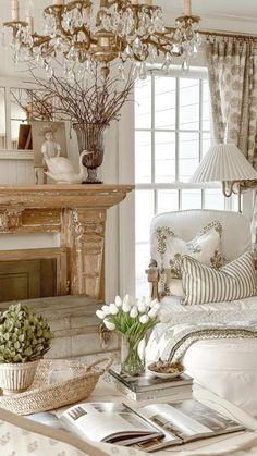 a living room filled with furniture and a chandelier hanging from the ceiling over a fire place