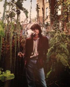 a man standing in front of some plants