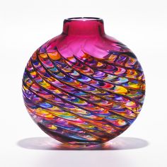 a colorful glass vase sitting on top of a white table