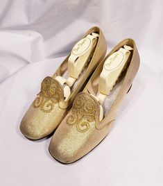 1960's gold lame' shoes with embroidered vamp and chunky heel Cute mid century modern pair of low heels. Size marked 7 B Measuresments: length ~ 9 1/2 inches, inside width ~ 2 3/4 inches, outside heel ~ 2 inches Sole reads: QualiCraft Worn 1x. These shoes are a ready to be worn! Buyer to pay all related shipping costs including insurance. Questions welcome. All Sales final Thank You CityVintage Gold Slip-on Heels For Formal Occasions, Retro Almond Toe Wedding Heels, Retro Round Toe Heels For Wedding, Gold Slip-on Heels For Wedding, Gold Slip-on Heels For Evening, Gold Low Heel Fitted Wedding Shoes, Gold Fitted Low Heel Wedding Shoes, Gold Almond Toe Heels For Galas, Gold Almond Toe Wedding Shoes For Party