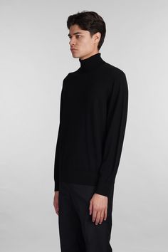 Knitwear in black wool, high collar, long sleeves, ribbed cuffs and bottom, 97% wool, 3% other fibers, Made in China, Model is 1. 83 and wears size M Black Turtleneck Sweater For Work, Classic Black Turtleneck For Fall, Wool High Neck Turtleneck For Winter, Black High Neck Turtleneck For Work, Black Business Sweater For Fall, Elegant Black Sweater With Ribbed Cuffs, Modern Fine Knit Turtleneck Sweater, Black Ribbed Turtleneck For Workwear, Black Formal Winter Sweater