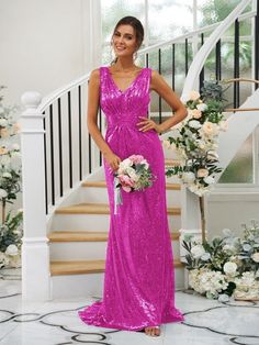 a woman in a bright pink dress standing next to some white flowers and staircases