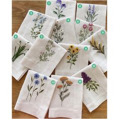 six embroidered tea towels with different flowers on them, labeled in green and blue numbers