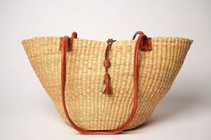 Our Boliga Baskets/Shoulder Bags are all handmade by Artisans from Bolgatanga in the North of Ghana. They are woven from elephant grass and are all uniquely made with adorably intricate design patterns, vibrant hand-dyed colours, incredibly flexible and durable. The leather handles are made from real goatskin. These Baskets/Bags make easy packaging for transportation as it can be flattened and later reshaped by simply spraying/dipping it in water (protect the handle from water), reshape to the d Artisan Woven Leather Shoulder Bag In Natural, Traditional Natural Woven Leather Shoulder Bag, Brown Palm Leaf Shoulder Bag For Travel, Travel Brown Palm Leaf Shoulder Bag, Traditional Natural Shoulder Bag For Everyday Use, Traditional Natural Shoulder Bag For Everyday, Traditional Natural Color Everyday Shoulder Bag, Artisan Brown Straw Travel Bag, Artisan Natural Shoulder Bag With Leather Handles