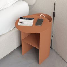 an orange table with a magazine on it next to a white couch and headboard