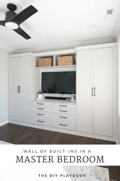 a white bedroom with built in cabinets and a tv on the wall, next to a ceiling fan