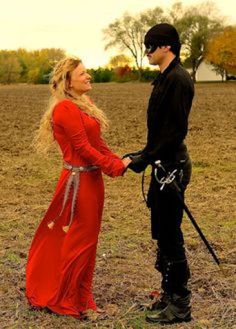 two people in costumes standing next to each other and one person is holding the hand of another