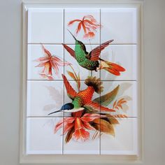 two colorful birds sitting on top of a white tile wall next to red and yellow flowers