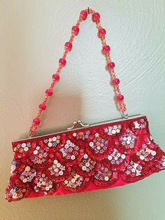 Unbranded: Dressy party Clutch!  Hand-beaded sequins, alphabet beads, flowers, and butterflies, on a red satin fabric make this unique.  This has a silver metal snap closure.  The interior lined in red satin.  The handle is made of red and white beaded balls.  Very clean with NO rips, tears, or stains.   Measurements:  11" wide across bottom                               2-1/2" deep                                4-1/2" tall (clutch only)  x 11" tall (to the top of the handle) Red Beaded Clutch For Party, Red Beaded Clutch Evening Bag, Red Embellished Clutch For Formal Occasions, Red Embellished Evening Bag For Festive Occasions, Red Beaded Evening Bag, Festive Red Embellished Evening Bag, Elegant Red Beaded Clutch, Red Beaded Evening Bag For Party, Red Sequined Party Bags