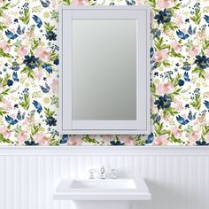 a white sink sitting under a mirror next to a wall mounted faucet in a bathroom