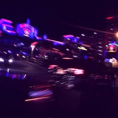 blurry photograph of neon signs in the city at night