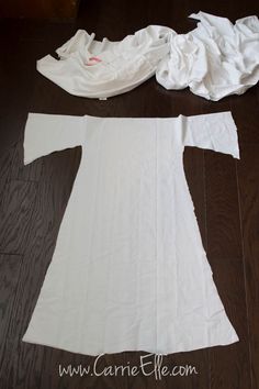 an unfinished white shirt laying on top of a wooden floor