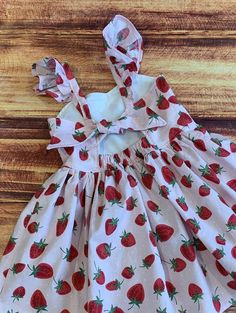 "Your little girl will love her summer strawberry twirly dress!  So perfect for a berry first birthday, a party, a birthday gift or everyday fun!   The bodice features a sweetheart neckline and is lined in a white cotton fabric.  The keyhole back ties with a knot with elastic at the back for a comfortable fit. The dress is easy care 100% cotton with the perfect twirling factor!  So much fun for play, parties and dress up occasions. There is an option available for flutter sleeves for a little dressier look. FINISHING:  All creations from Little Giggle Shop have been handmade in a smoke-free home with a Grandmother's Love. I take great pride in the quality of my designs.  The time is taken to professionally finish all edges which helps to prevent fraying in both washing and wearing.   CARE: Sweet Summer Dress For Picnic, Sweet Spring Dress For Picnic, Sweet Spring Dresses For Picnic, Sweet Spring Picnic Dress, Cute Cherry Print Summer Dress, Whimsical Summer Dress For Tea Party, Pink Strawberry Print Dress For Party, Red Strawberry Print Party Dress, Whimsical Summer Tea Party Dress