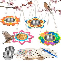 bird feeders hanging from branches with flowers and birds on them