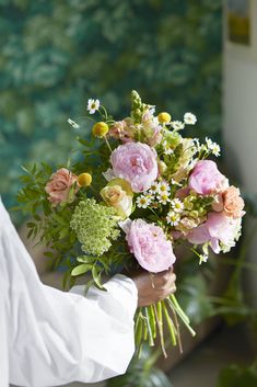 a person holding a bouquet of flowers in their hand