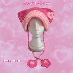 a pink crocheted hat and mittens on top of a mannequin head