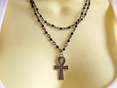 Without a doubt, this necklace is going to gather compliment after compliment for you! The double strand black beaded chains are tiny hematite beads, and the classic Egyptian Ankh has attitude and charm! I have other necklaces in similar styles, both choker length like this as well as longer chains - look for them here in the shop: https://www.etsy.com/shop/ChathamsCrossing/search?search_query=rosary&order=date_desc&view_type=list&ref=shop_search Egyptian Ankh, Ankh Necklace, Beaded Cross, Cross Chain, Crystal Choker, Hematite Beads, Double Chain, Cross Pendant Necklace, Lariat Necklace